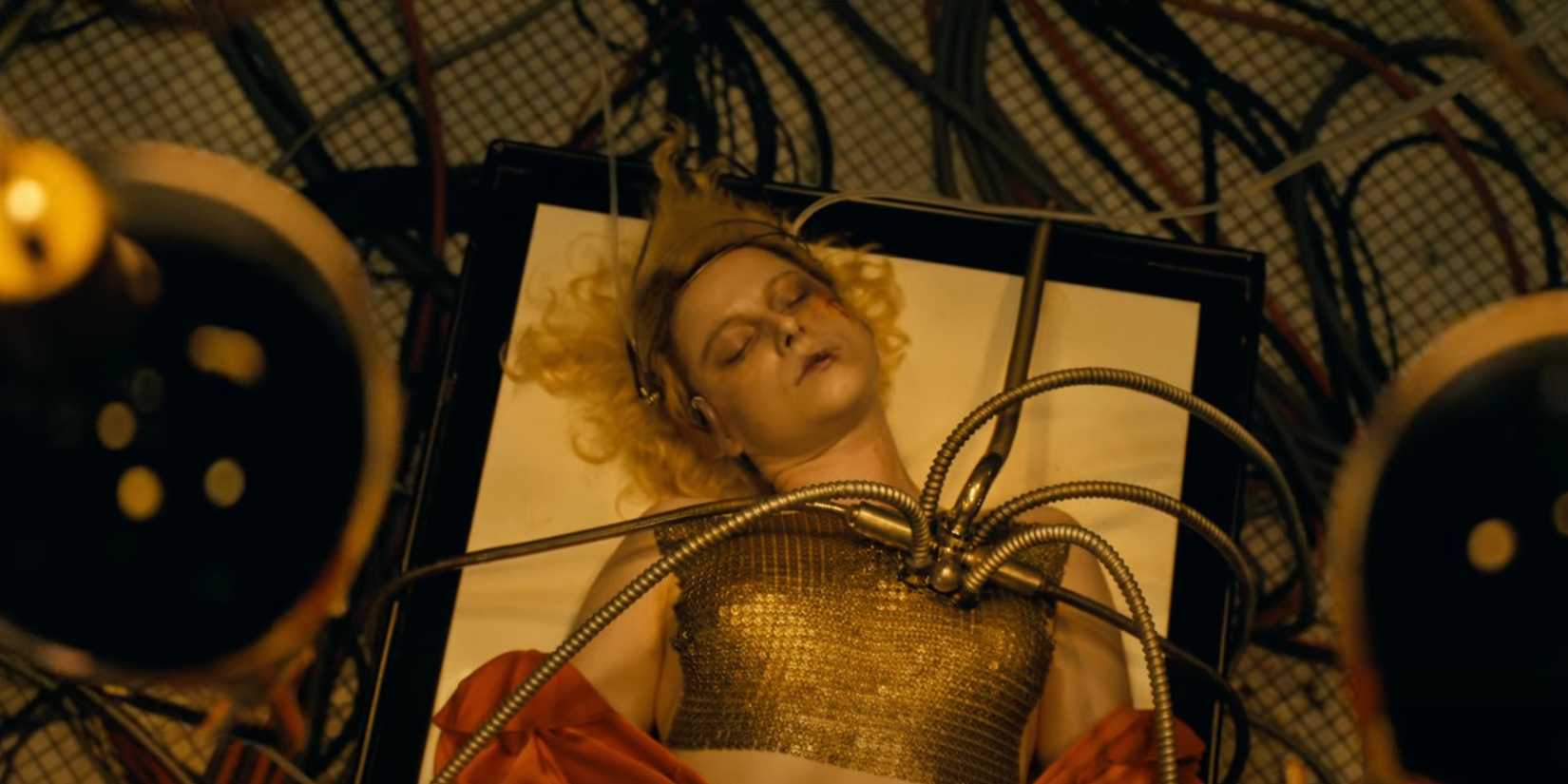 Jessie Buckley lying unconscious on a table in The Bride