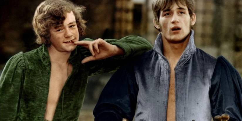 Two young men stand looking while wearing tunics in The Canterbury Tales 