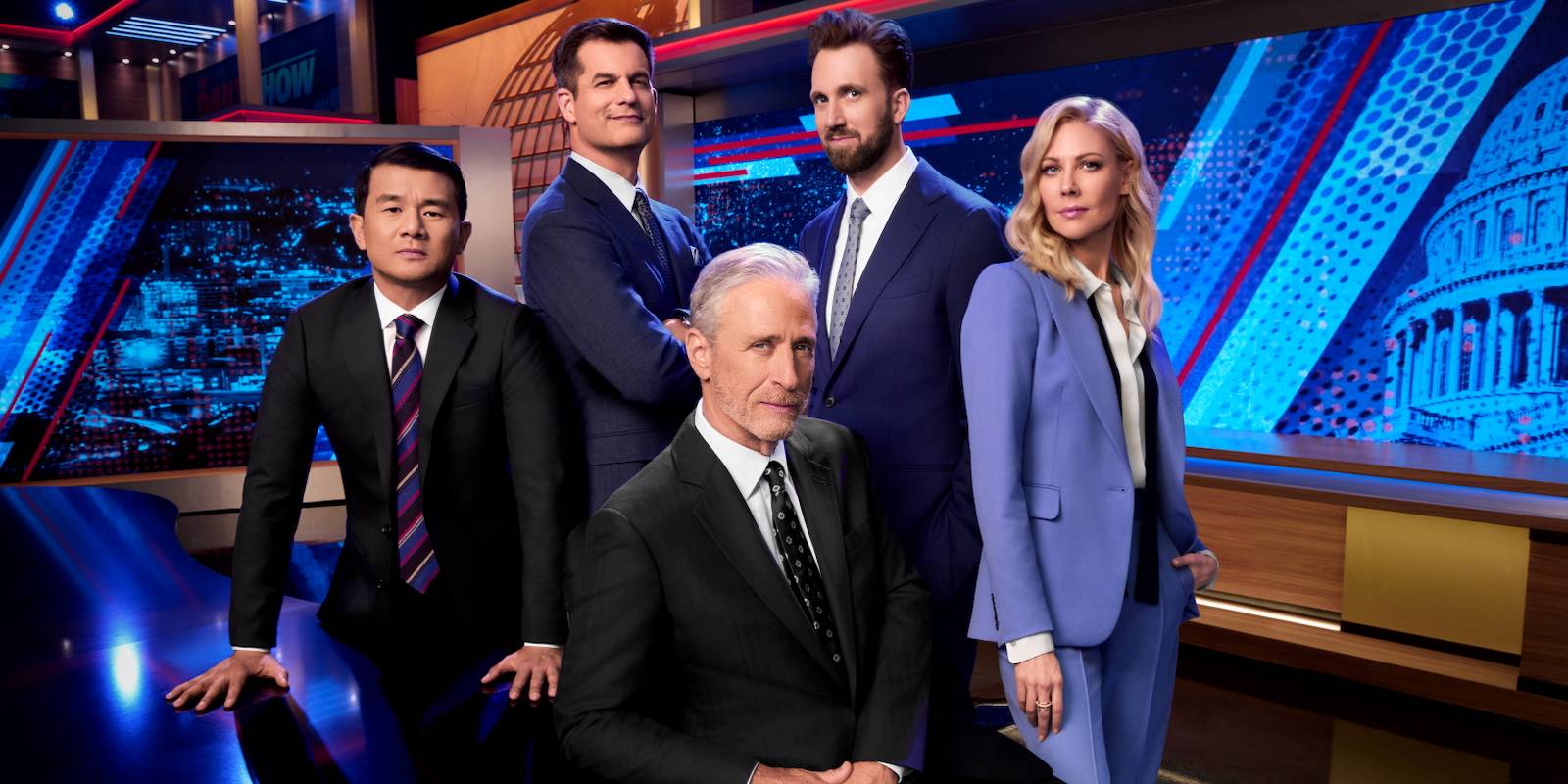 The Daily Show cast members pose on the set for a publicity photo