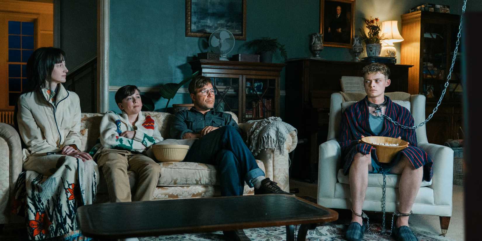The family in Good Boy sits next to their chained prisoner in the film