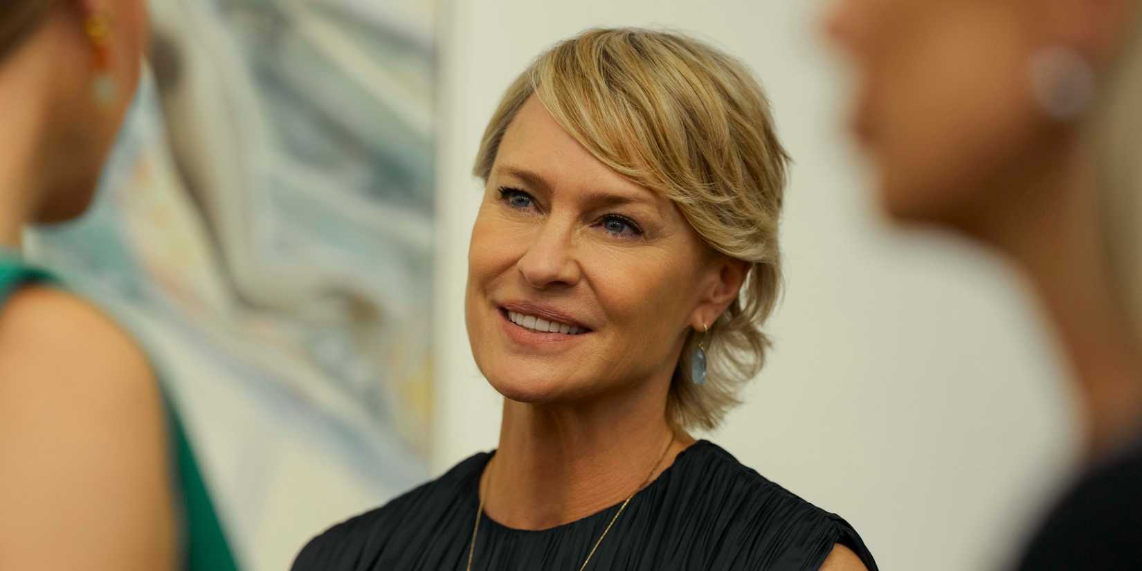 Laura smiles while looking at someone in The Girlfriend