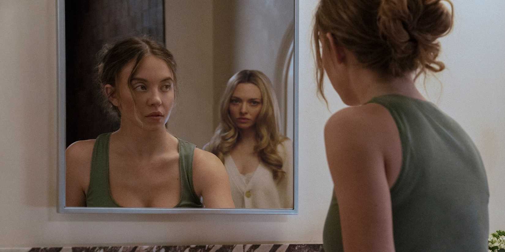 Sydney Sweeney looking in the mirror at Amanda Seyfriend behind her in The Housemaid