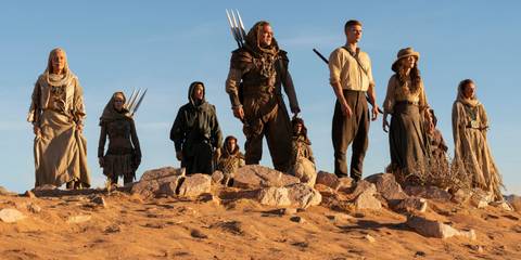 The Wheel of Time cast standing in the desert looking at something offscreen in The wheel of Time