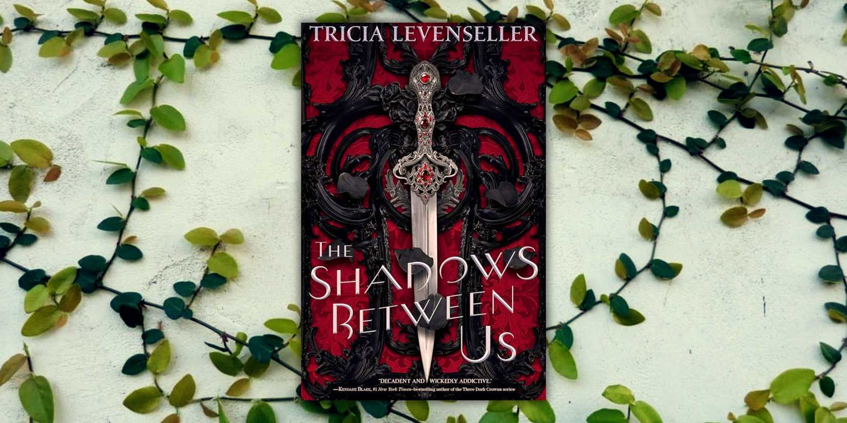 The cover of the book The Shadows Between Us over a wall of vines