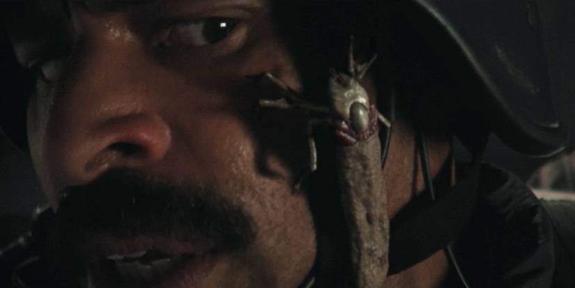 A tick-like alien lifeform crawling on a Prodigy soldier's face in Alien: Earth season 1, episode 1