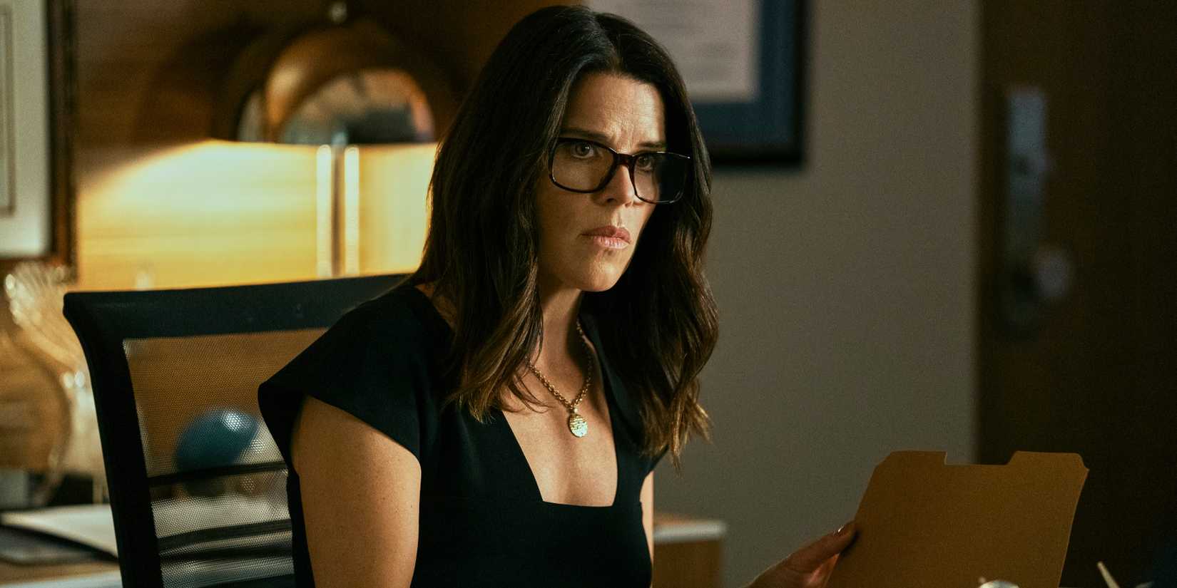 Maggie McPherson, played by Neve Campbell, sits at her desk in The Lincoln Lawyer season 1