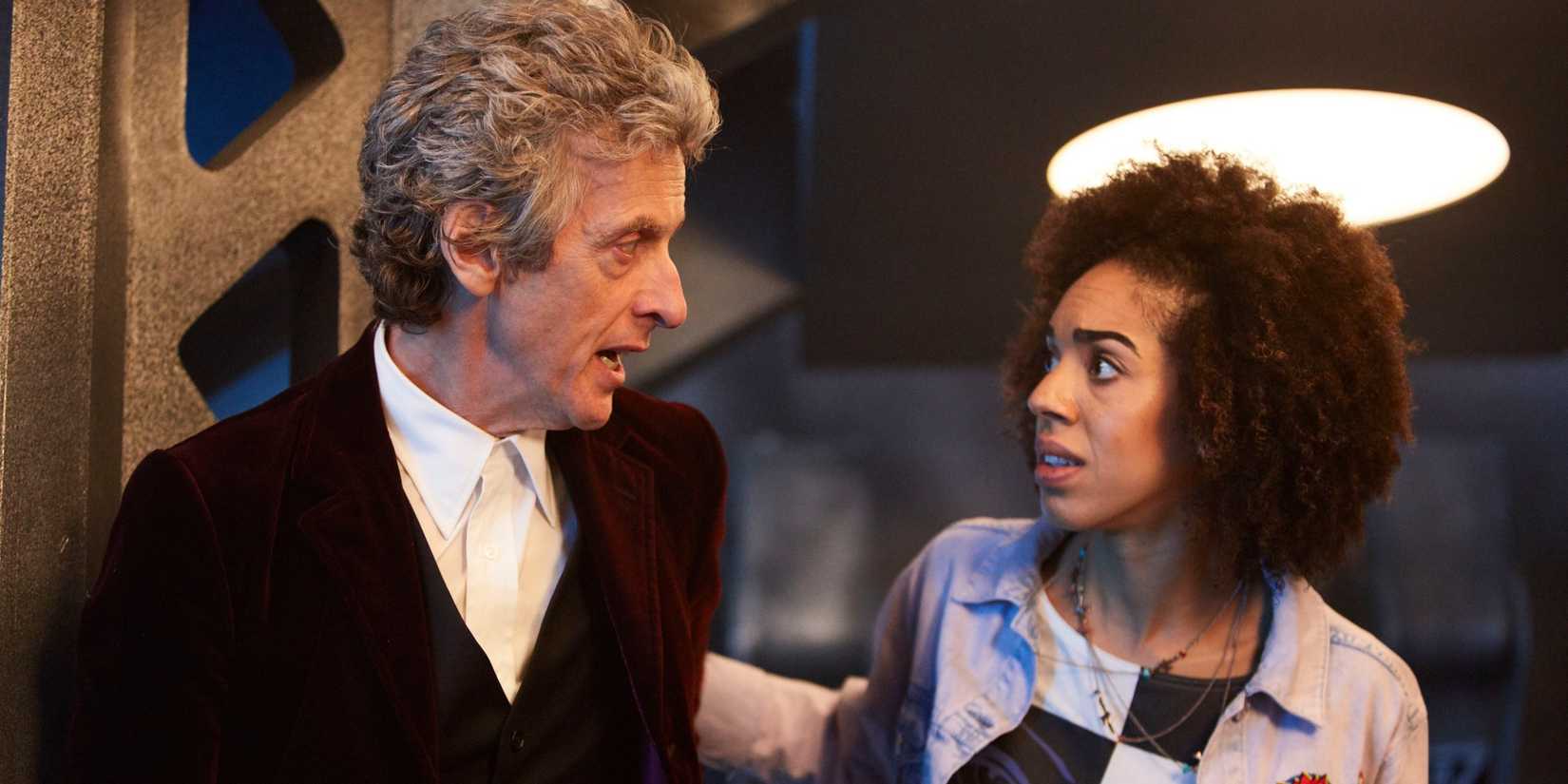 The Twelfth Doctor and Bill staring at each other as they hide from a Dalek in the Doctor Who episode “The Pilot.” 