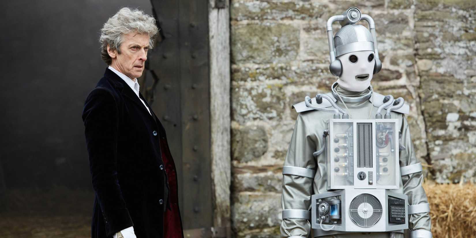 The Twelfth Doctor standing with Cyberman Bill in front of a barn, staring out at something, in the Doctor Who episode “The Doctor Falls.” 