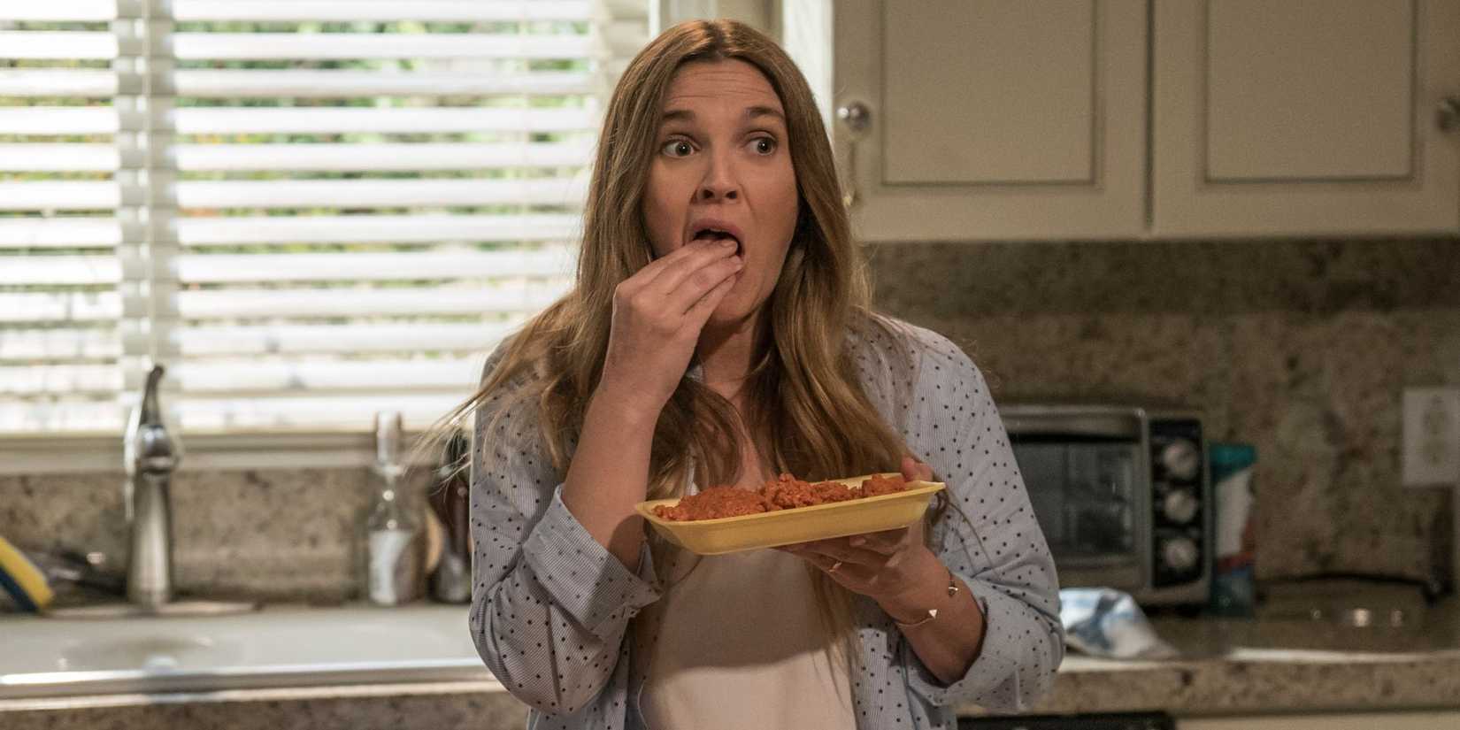 Drew Barrymore eating raw meat in a suburban kitchen