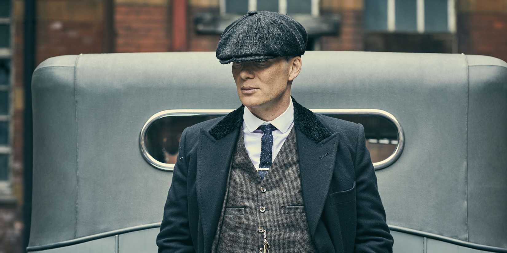 Cillian Murphy leaning against a car in Peaky Blinders