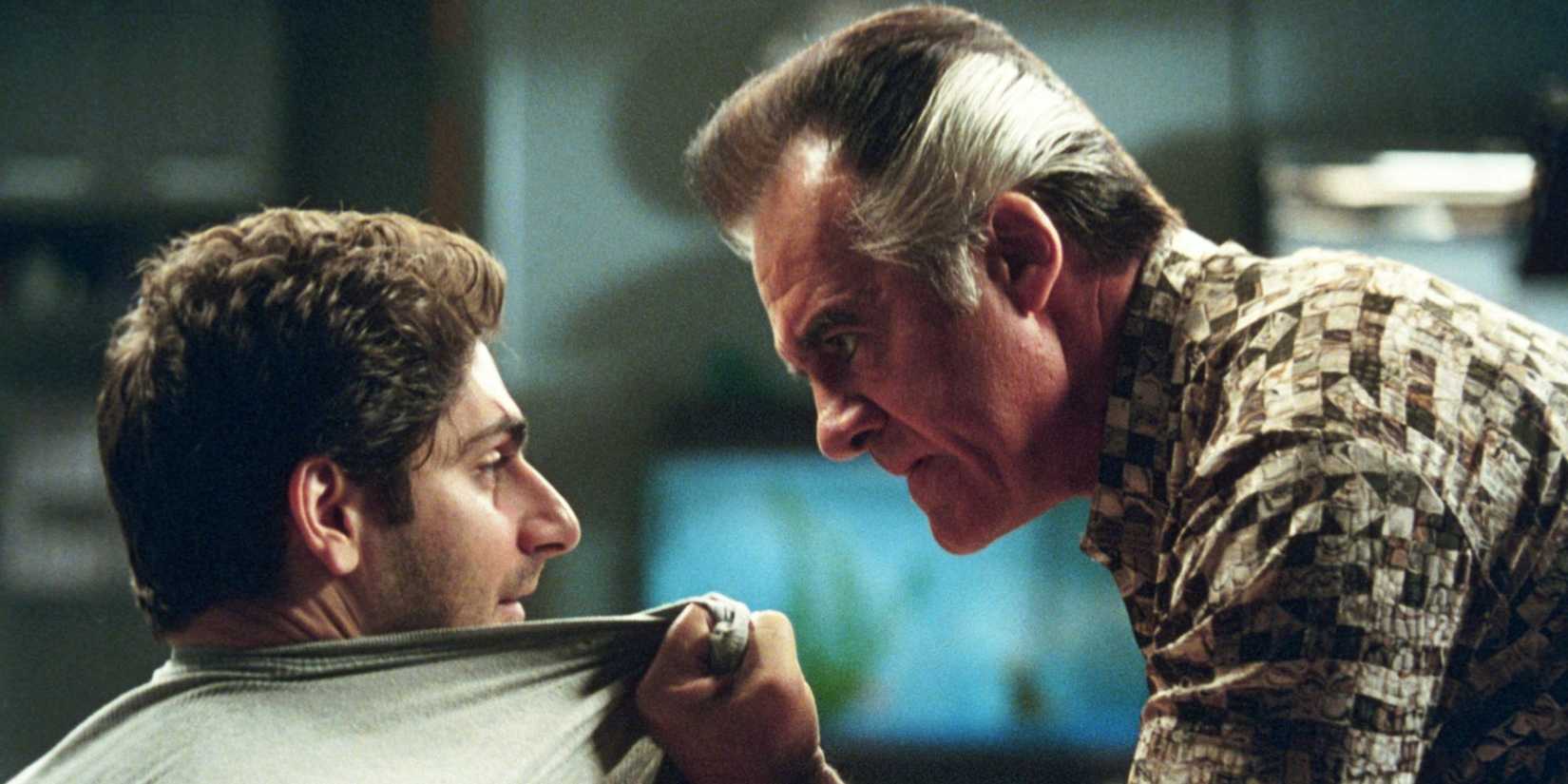 Paulie grabs Christopher by the front of his shirt.