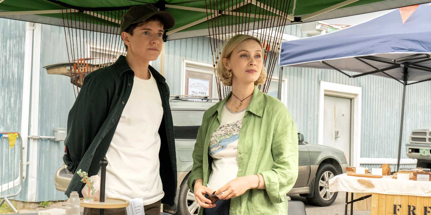 Alex and Sarah stand in the outdoor market in Wayward.