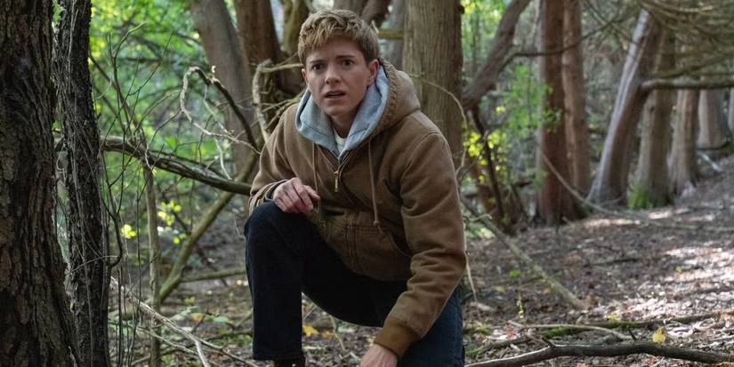 Alex kneeling in the woods in Wayward