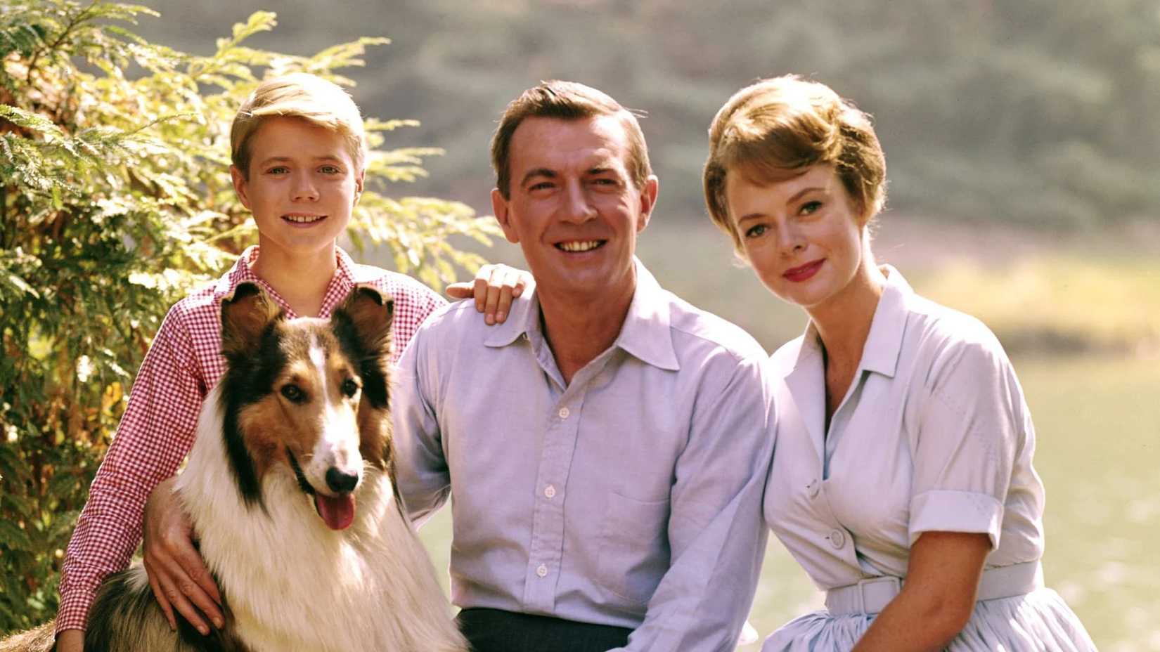 The family gathered together around the dog in Lassie