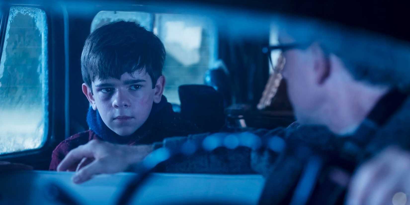 Menino no banco de trás de um carro em It: Welcome to Derry