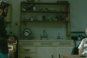 A standing Hank talks to a sitting Alma in After the Hunt