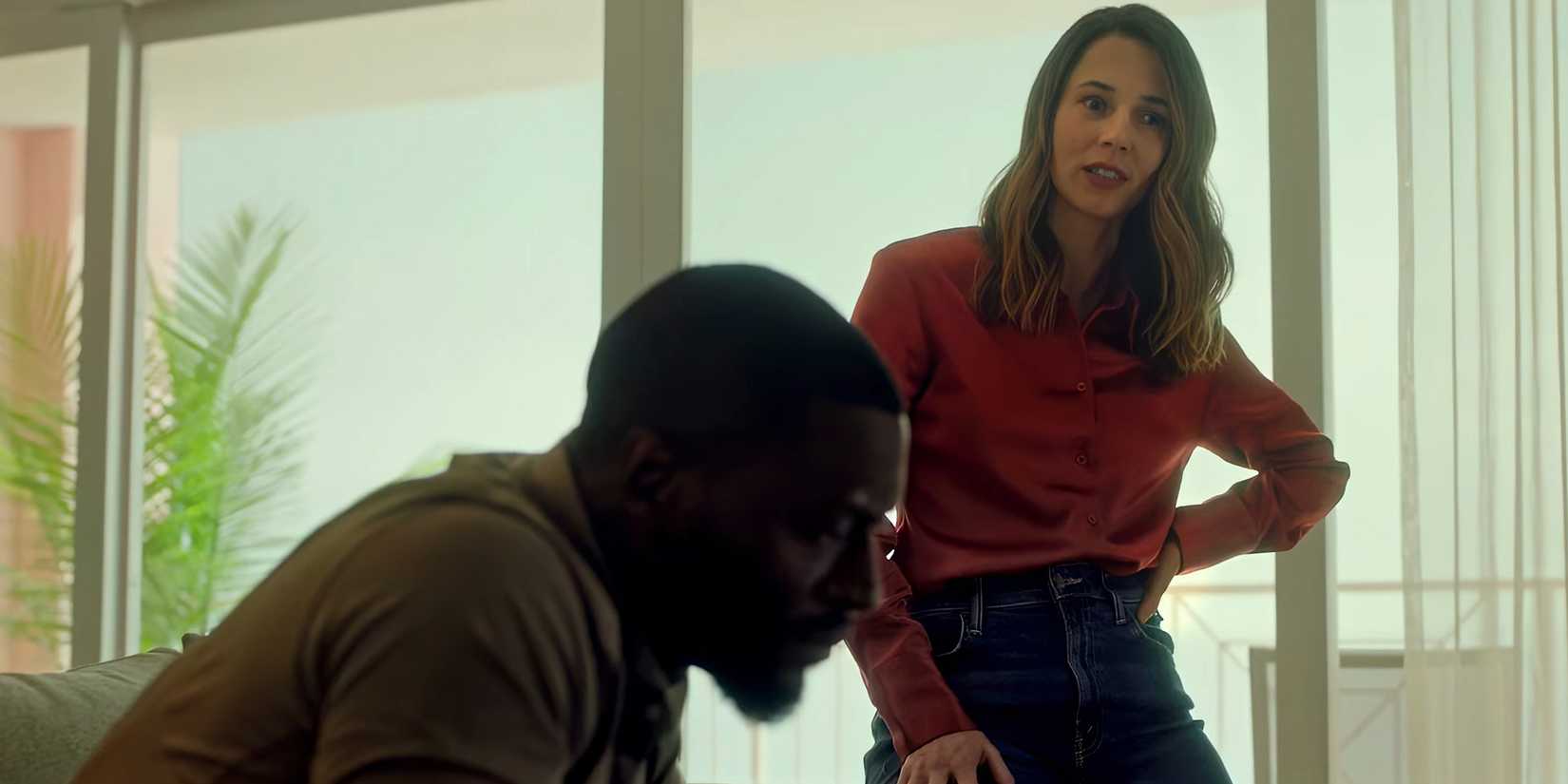 Alona Tal's Kayla looking in thought while Aldis Hodge's Alex looks at something in Cross season 2