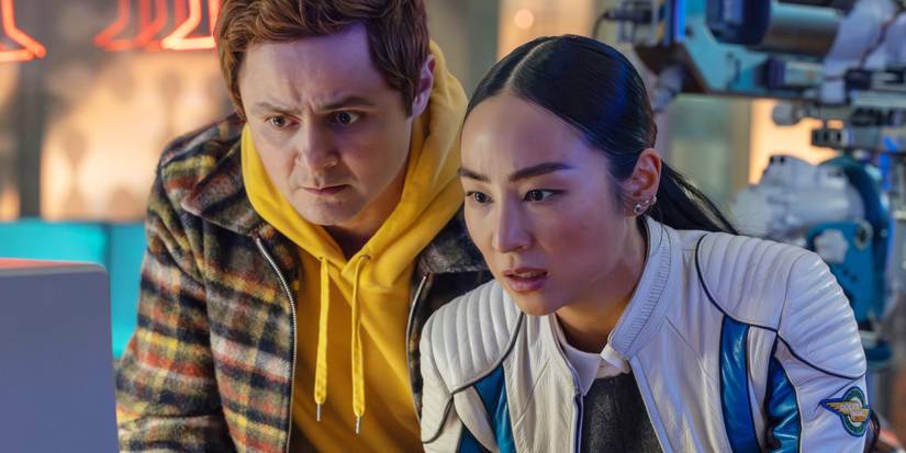 Arturo Castro and Greta Lee looking at a computer with concern in Tron Ares