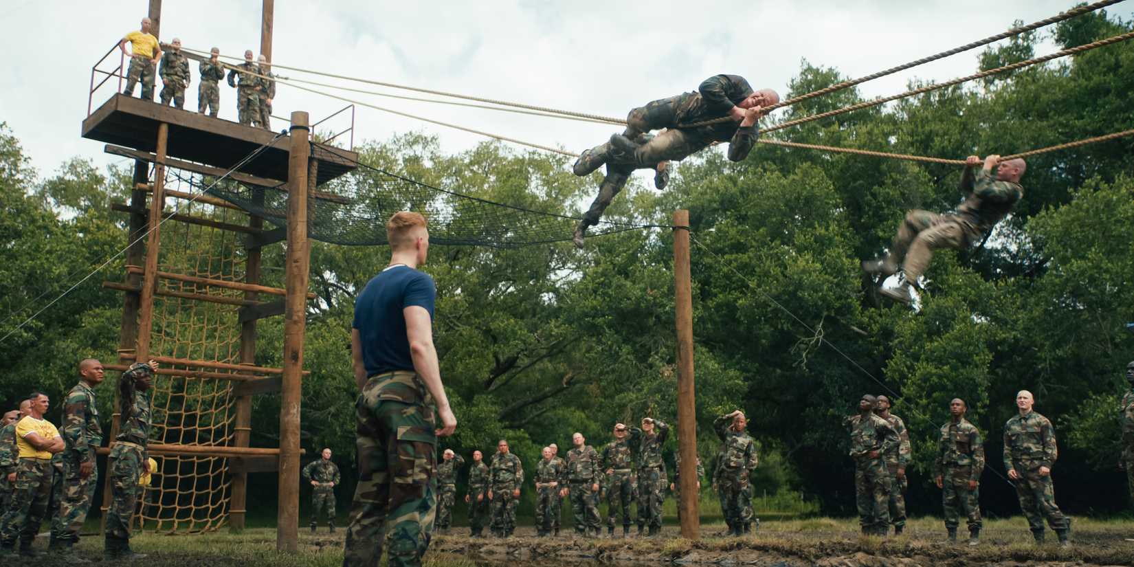 Sgt. Sullivan watches as Cody and Slovacek crawl across a rope in the confidence obstacle course in Boots