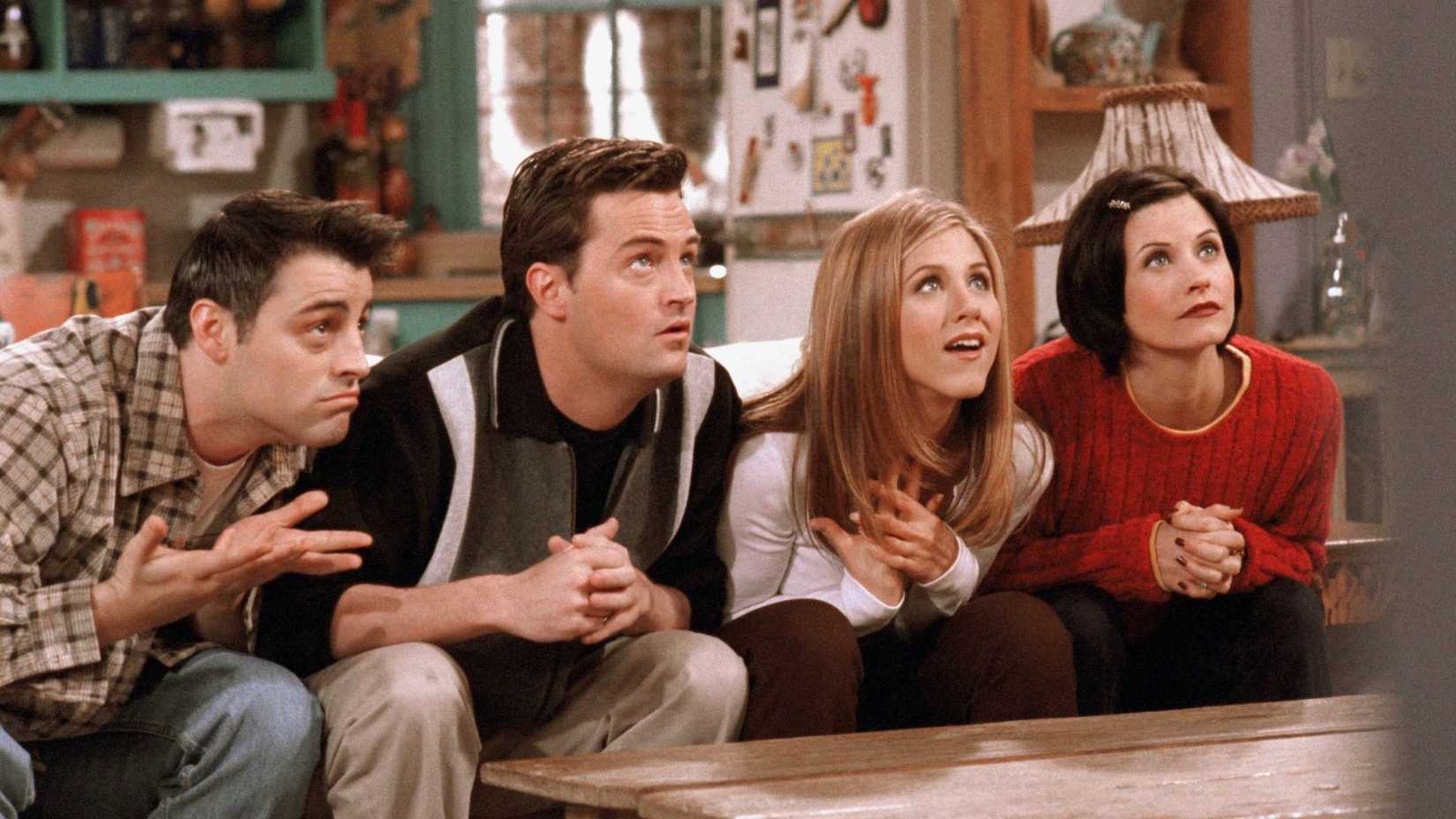 Chadler, Monica, Rachel, and Joey sitting excitedly on the couch in Friends
