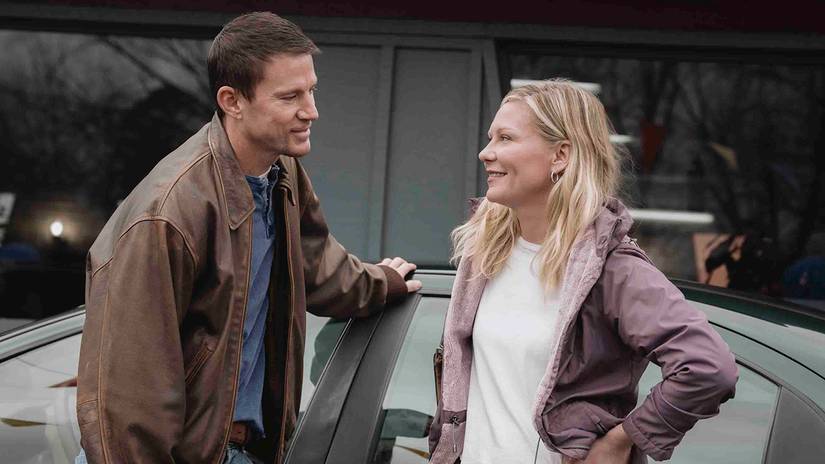 Jeff von Channing Tatum und Leigh von Kirsten Dunst lehnen sich in „Roofman“ an ein Auto