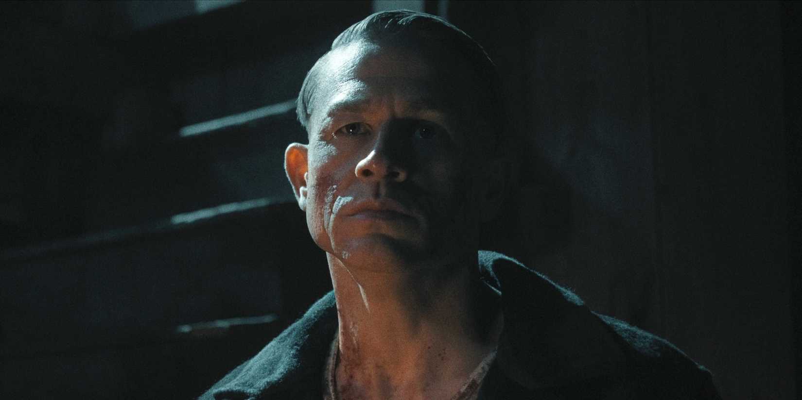 Charlie Hunnam's Ed Gein stands outside in the dark from Monster The Ed Gein Story
