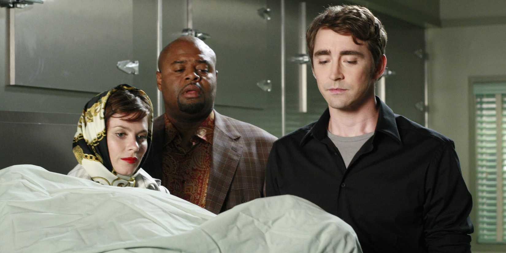 Chuck Emerson e Ned olhando para um cadáver coberto com um cobertor em Pushing Daisies
