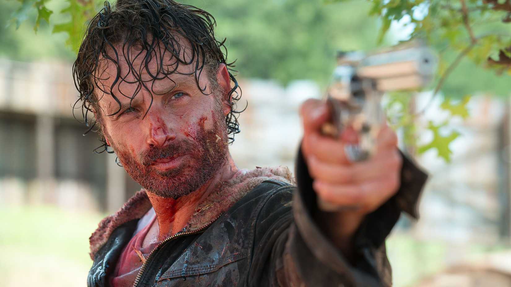 Close-up of a sweaty Rick Grimes wielding a handgun in The Walking Dead