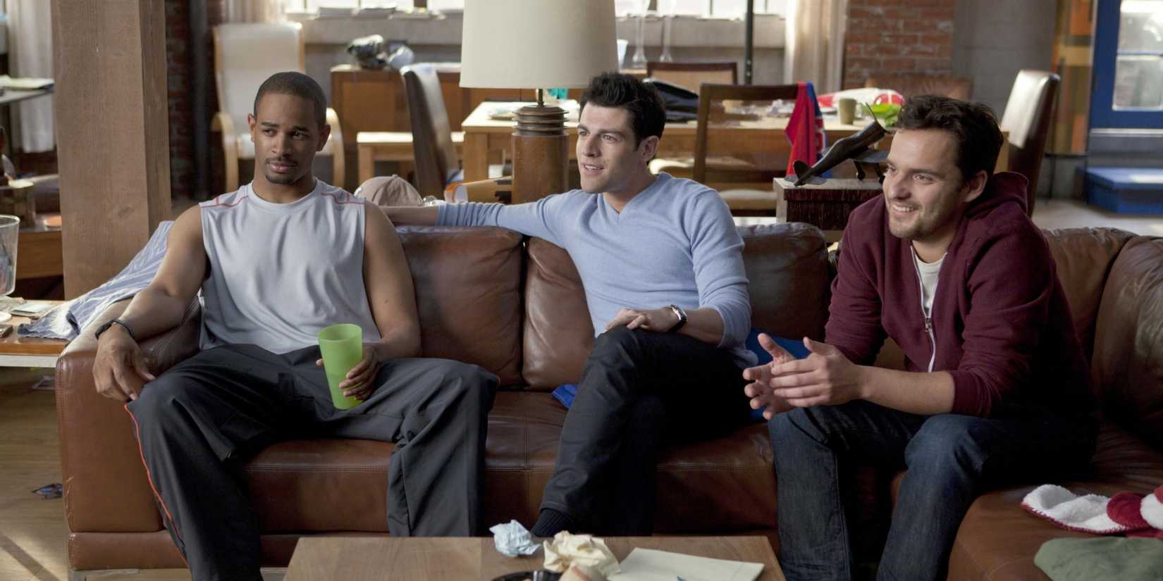 Coach Schmidt e Nick sentados no sofá do loft em New Girl.