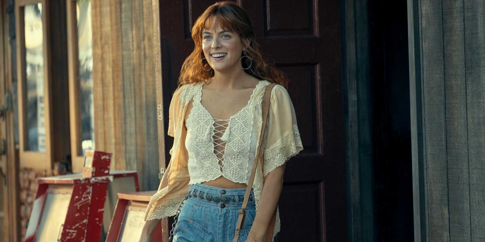 Daisy Jones (Riley Keough) saindo por uma porta em Daisy Jones & The Six