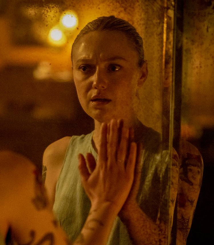 Dakota Fanning's Polly looking worried into a mirror in Vicious