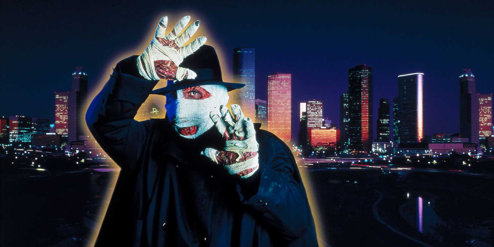Darkman with his hands up against a city skyline in Darkman II the Return of Durant
