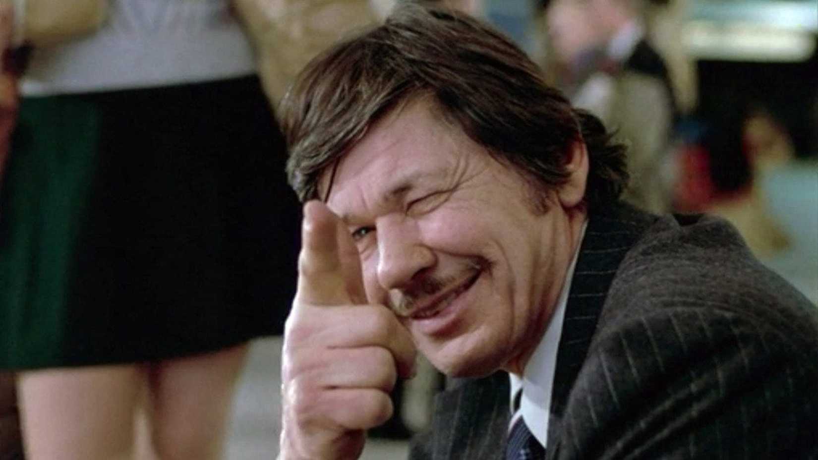 Charles Bronson smiles while pointing finger guns at someone in Death Wish