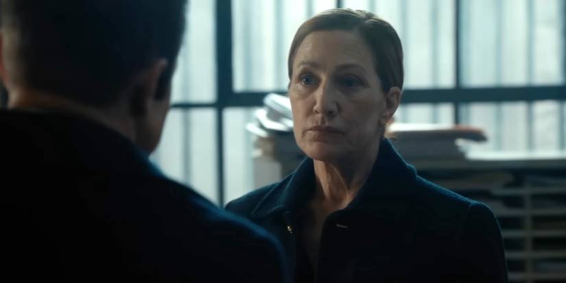 Edie Falco como Nina olhando seriamente para Jeremy Renner como Mike na quarta temporada de Mayor of Kingstown.