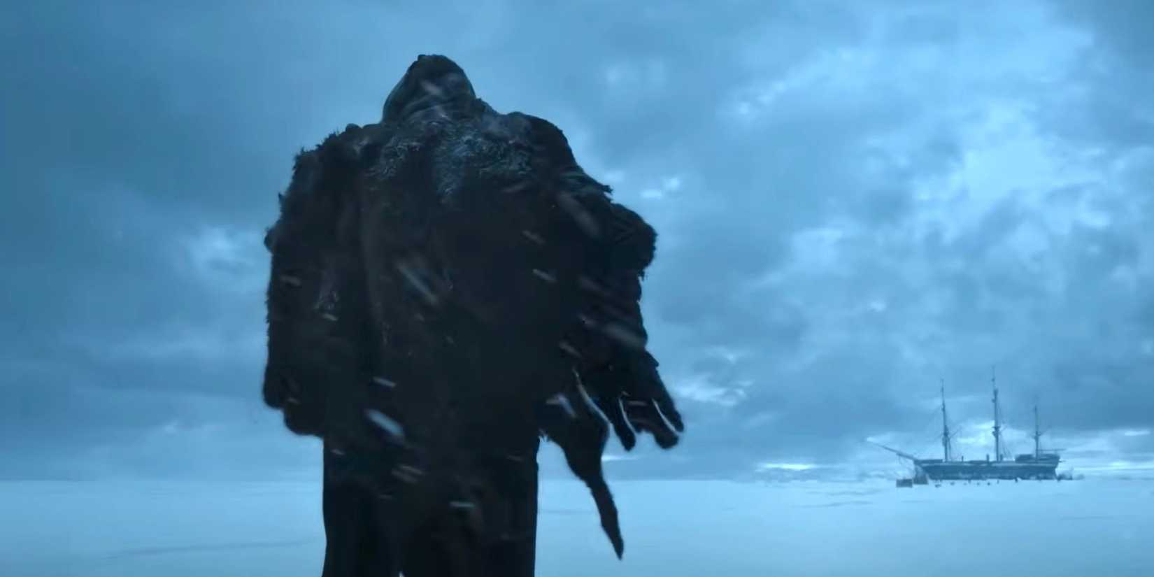 A criatura de Frankenstein caminhando na neve de costas na câmera no filme Frankenstein