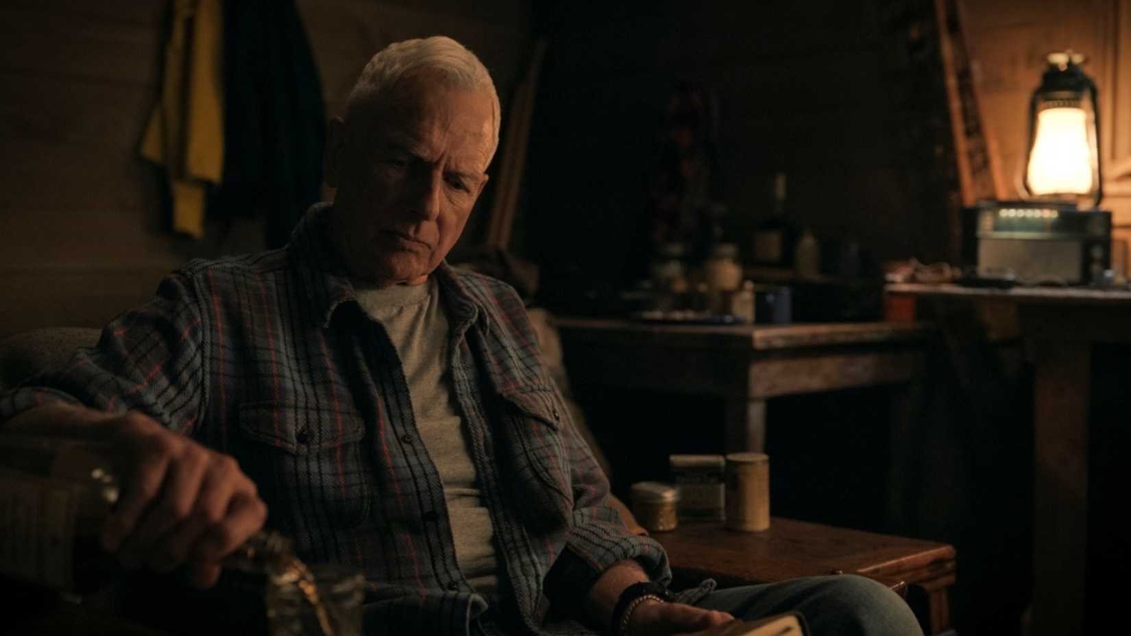 Gibbs sits on a couch in