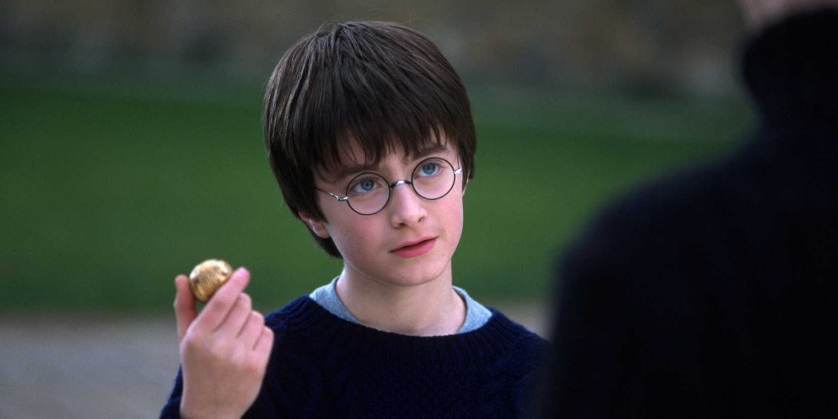Harry Potter (Daniel Radcliffe) holding the snitch in Harry Potter and the Sorcerer's Stone