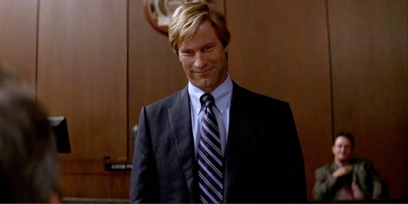Harvey Dent sorrindo para um réu no tribunal em O Cavaleiro das Trevas