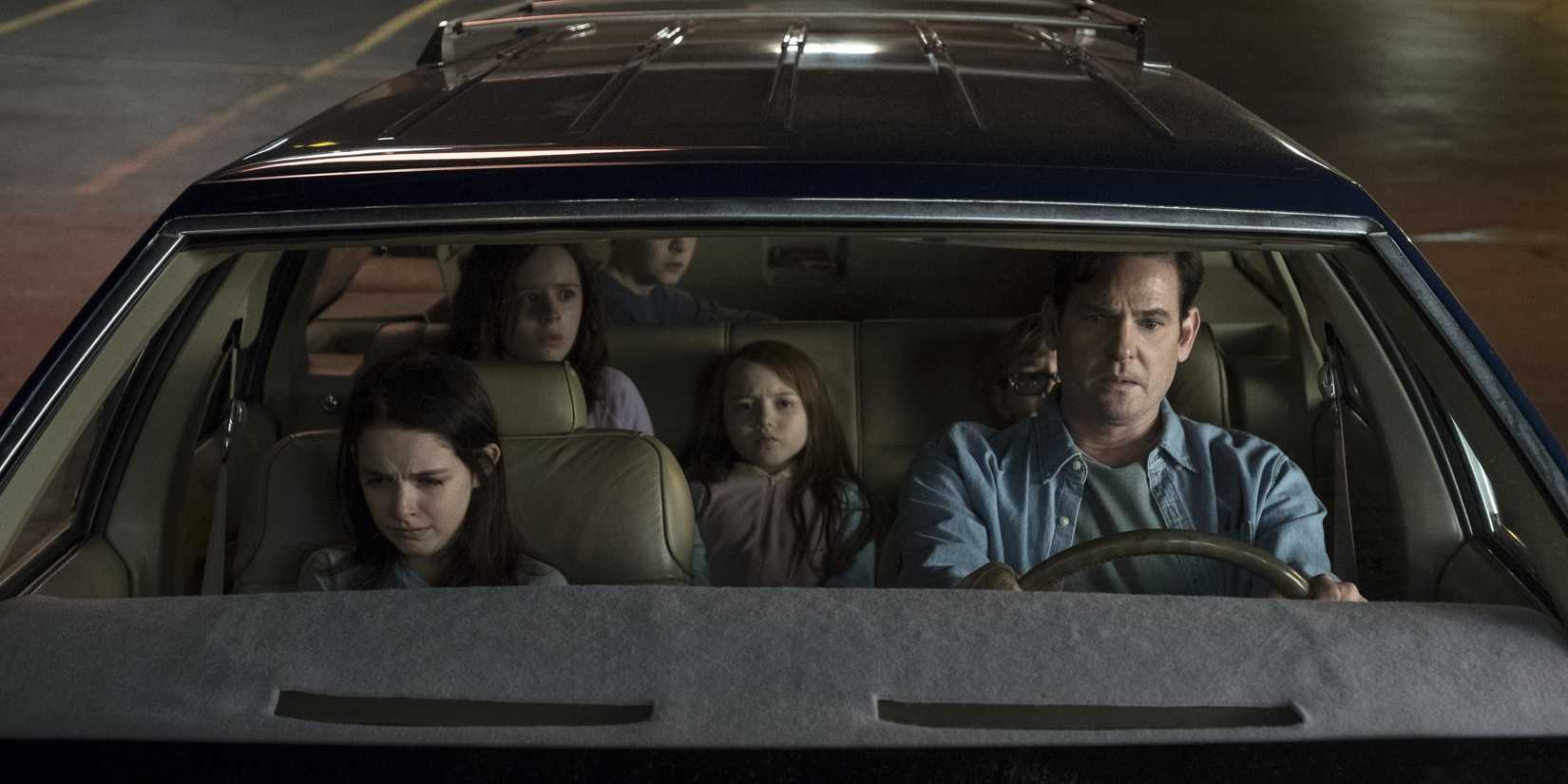 Hugh com seus filhos pequenos assustados no carro em The Haunting of Hill House