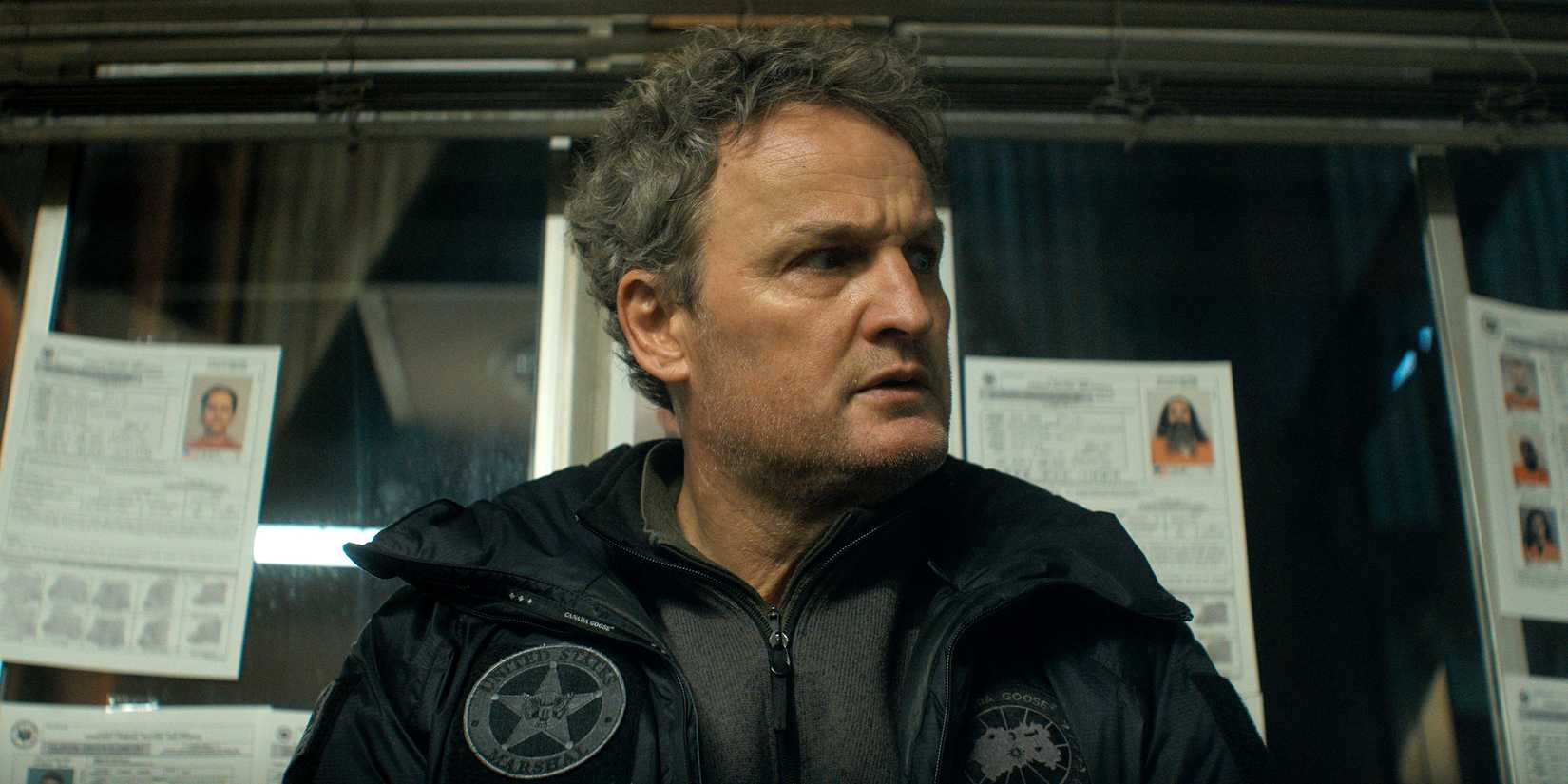 Jason Clarke as Frank looking intensely while in front of the evidence board in The Last Frontier