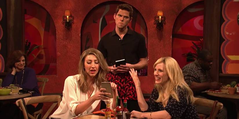 Jessica Chastain and Heidi Gardner arguing about a bill with Mikey Day looking annoyed in Taco Math on SNL.