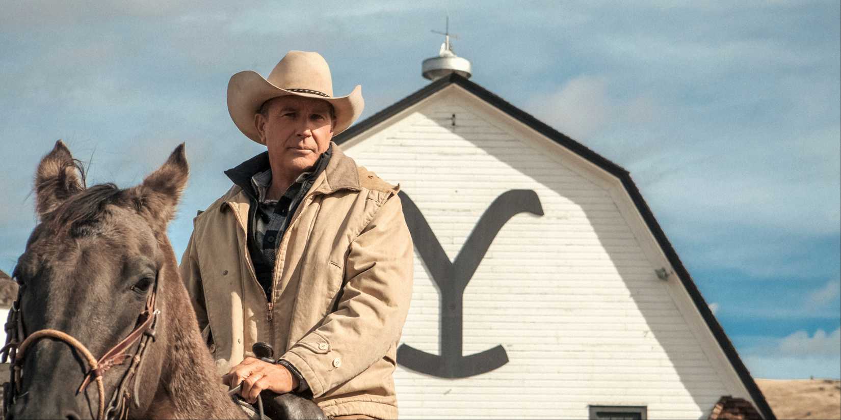John Dutton (Kevin Costner) on his horse in front of the Yellowstone barn in Yellowstone