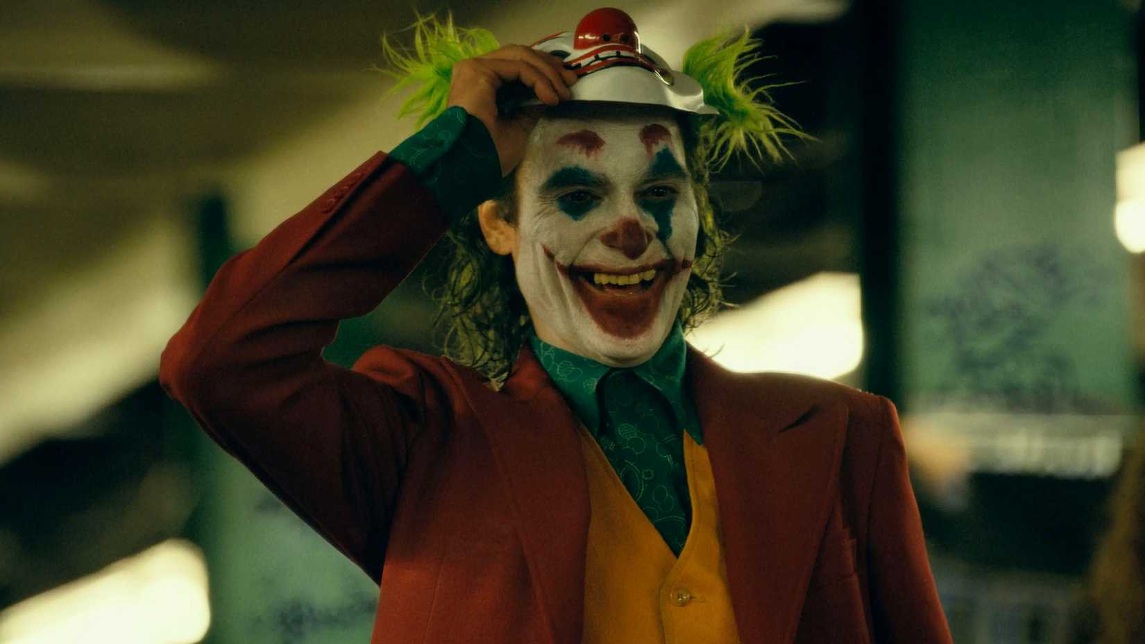 Joker laughing and lifting a clown mask in the Joker movie