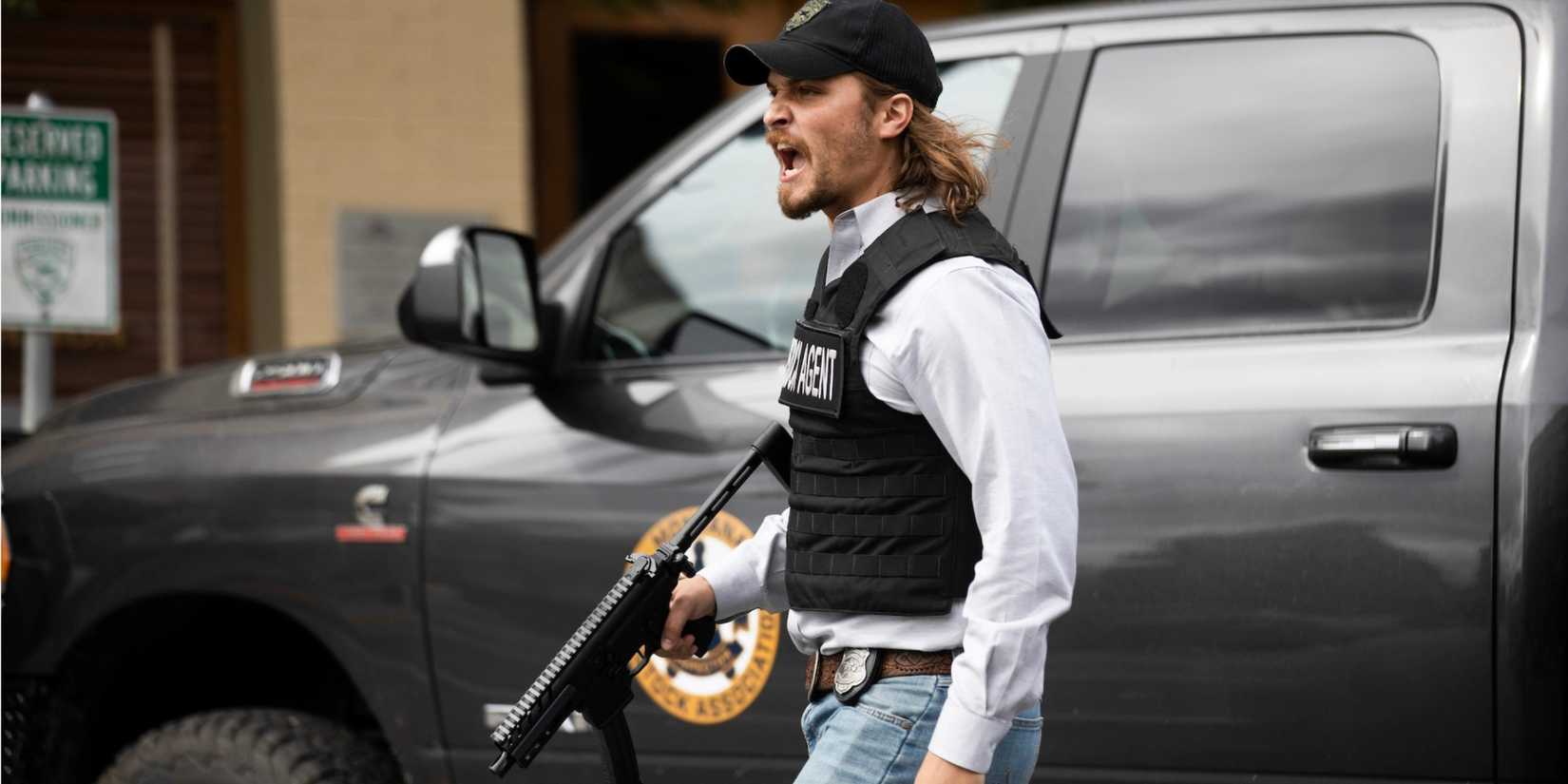 Kayce Dutton (Luke Grimes) in a bulletproof vest with a gun yelling in Yellowstone