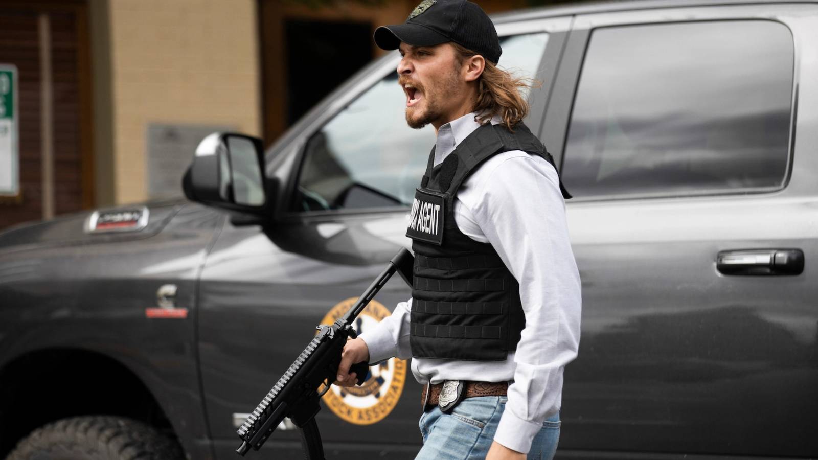 Kayce Dutton (Luke Grimes) in a bulletproof vest with a gun yelling in Yellowstone