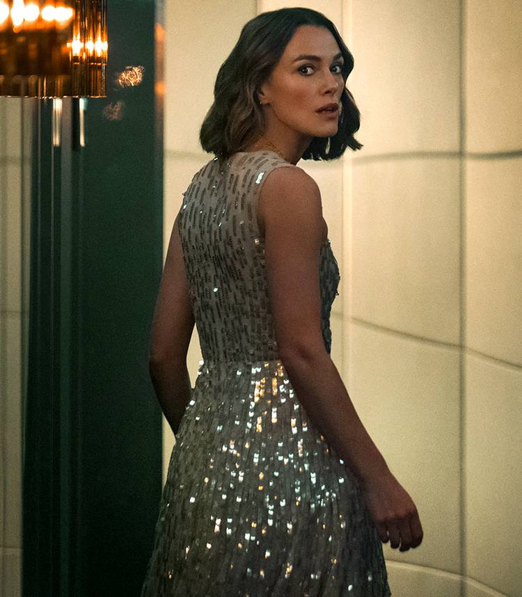 Keira Knightley's Lo looking over her shoulder while walking down a hallway in The Woman in Cabin 10