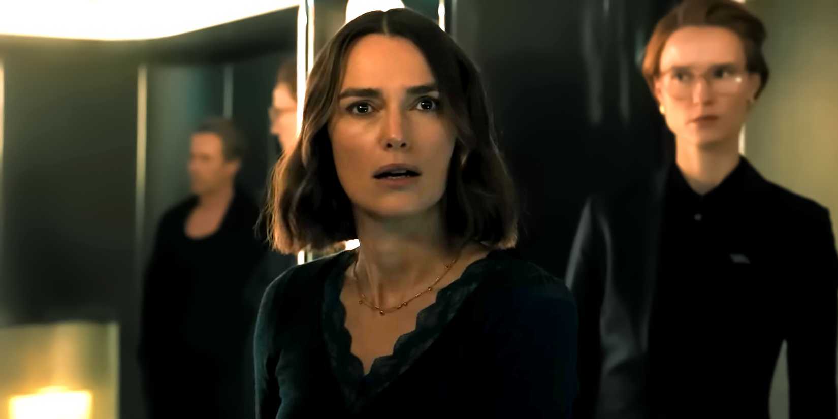Keira Knightley's Lo looking surprised while someone stands behind her in The Woman in Cabin 10