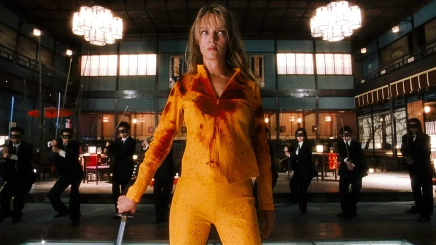 The Bride stands with her back to men in masks with swords in Kill Bill