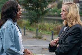Maggie talking to a severe looking Alma in After the Hunt