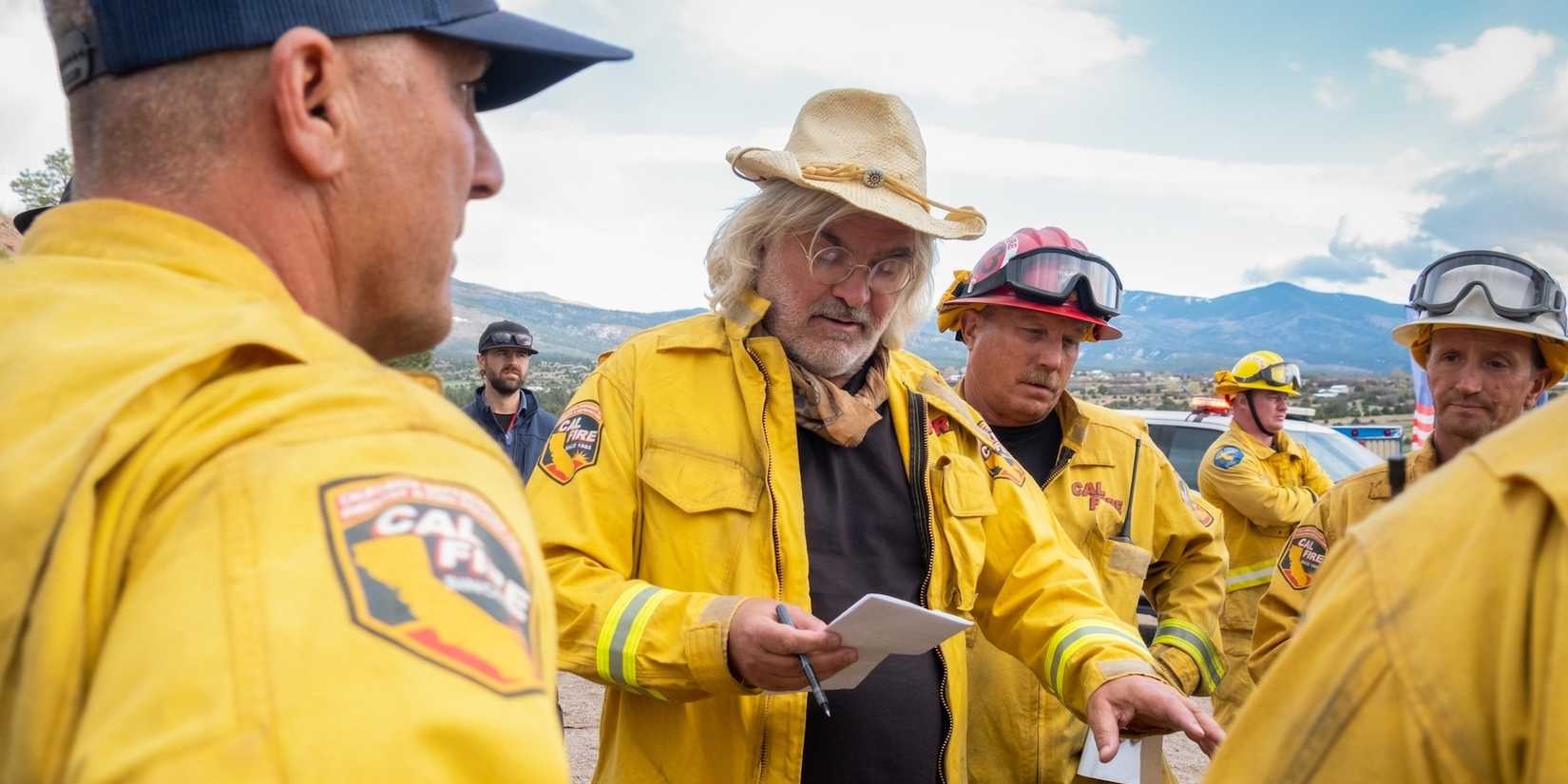 Paul Greengrass speaks with firefighters while directing The Lost Bus